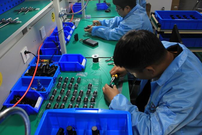 technician busy working in Novelty point optics factory